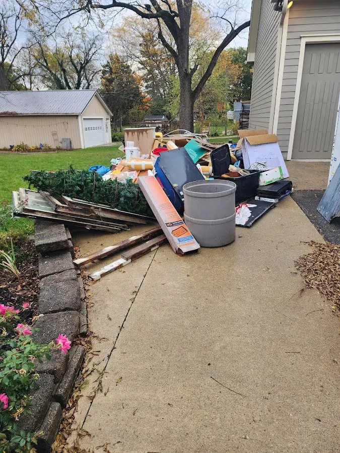 Dumpster being loaded with debris for 12 Yard Dumpster Rental in Falmouth